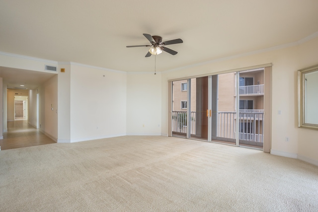 carpeted spare room featuring crown molding and ceiling fan