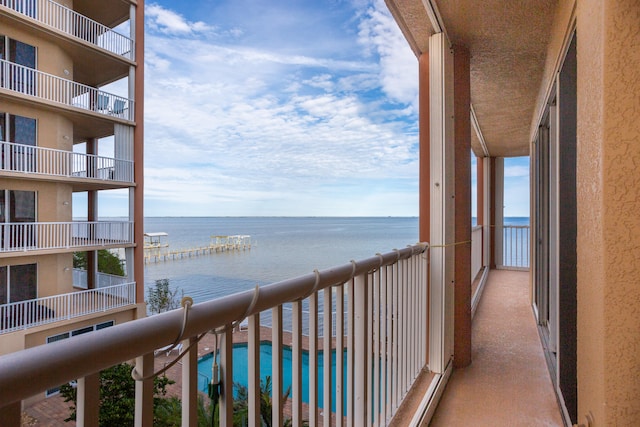 balcony with a water view and a community pool