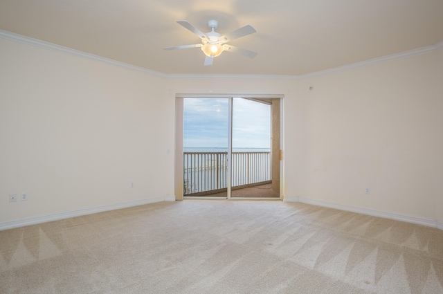 carpeted empty room with ceiling fan and ornamental molding