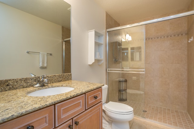 bathroom featuring oversized vanity, toilet, tile floors, and walk in shower