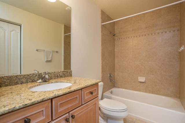 full bathroom with tiled shower / bath combo, vanity, tile floors, and toilet