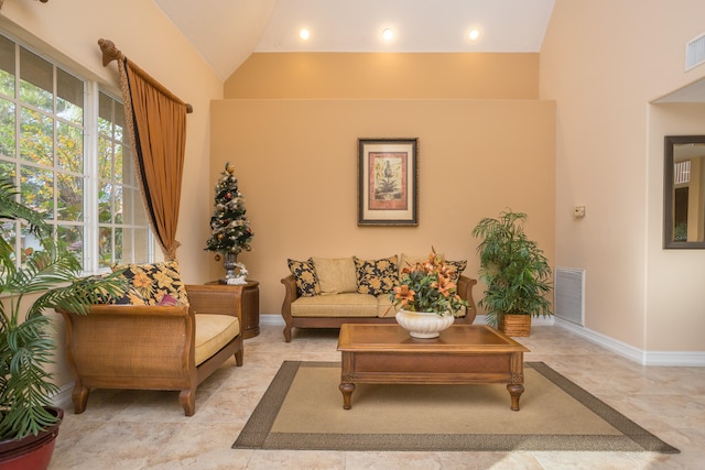 living room with light tile floors and high vaulted ceiling