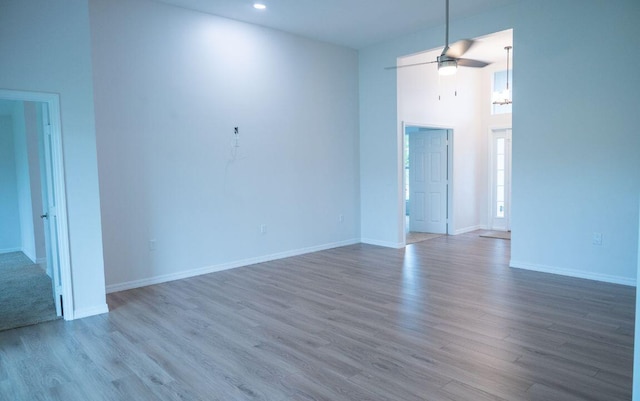 unfurnished room featuring ceiling fan, dark wood-type flooring, and a high ceiling