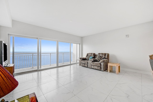 tiled living room featuring a water view