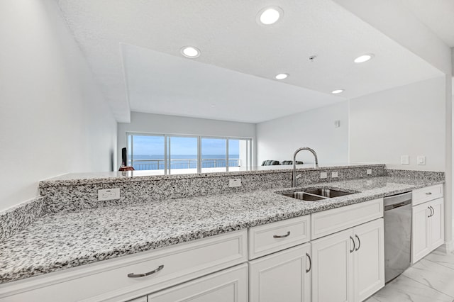 kitchen with light stone countertops, sink, a water view, light tile floors, and dishwasher