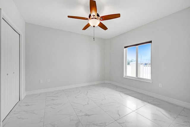 tiled empty room featuring ceiling fan