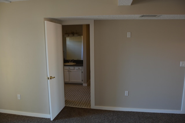 empty room with dark tile flooring and sink