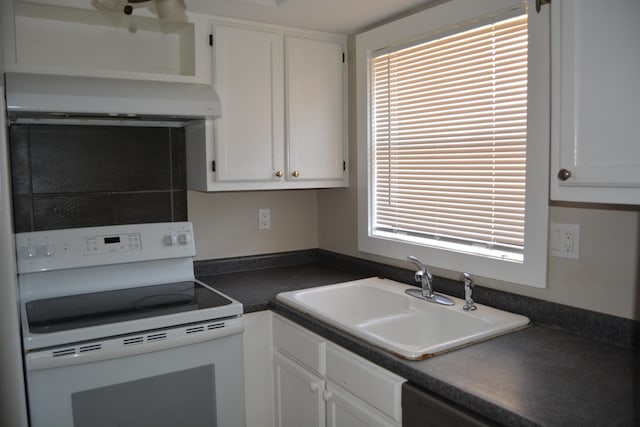 kitchen featuring wall chimney range hood, white range with electric cooktop, white cabinets, and sink