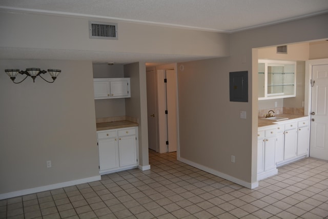 kitchen with white cabinets, light tile floors, and sink