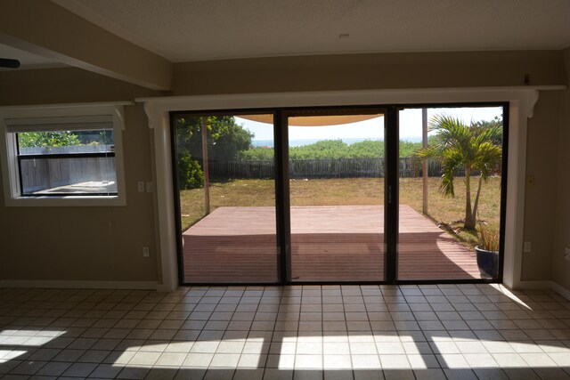 doorway with a wealth of natural light and tile flooring