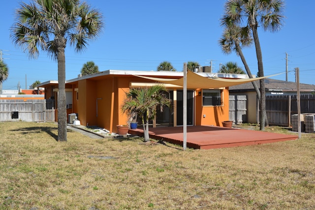 rear view of house featuring a wooden deck, a yard, and central air condition unit