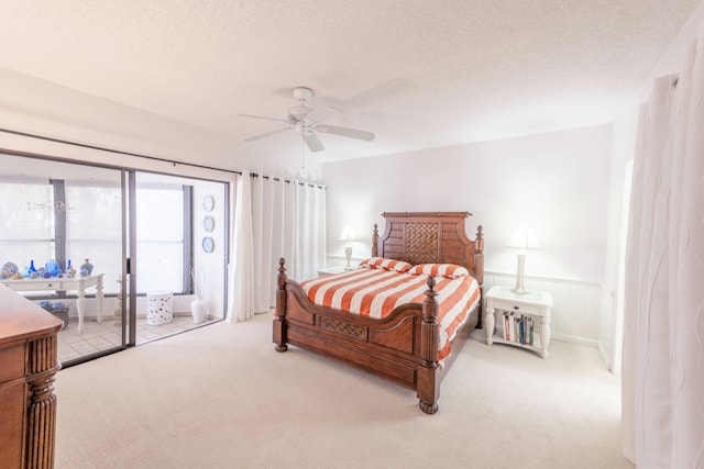 carpeted bedroom with access to outside, a textured ceiling, and ceiling fan