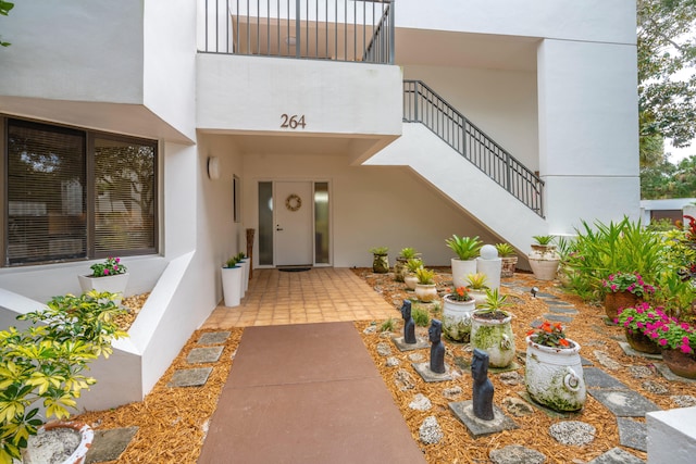 view of exterior entry with a balcony and a patio area