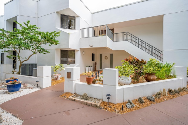 view of front facade featuring a balcony and central AC unit