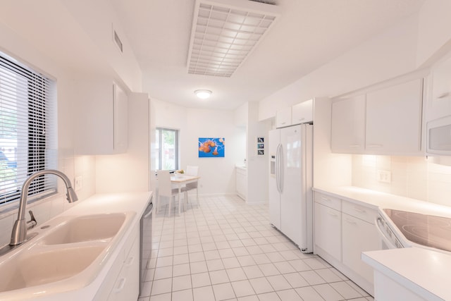 kitchen with light tile floors, tasteful backsplash, white appliances, white cabinets, and sink