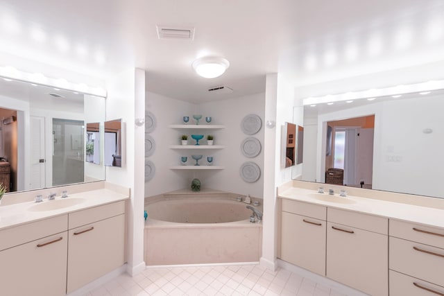 bathroom with large vanity, tile floors, and a bath to relax in