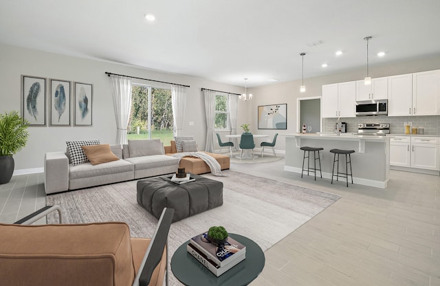 living room featuring light wood-type flooring and an inviting chandelier