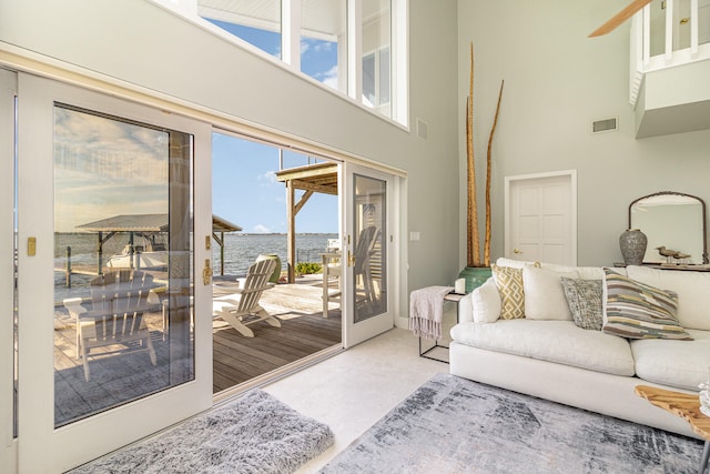 living room featuring a high ceiling and a water view