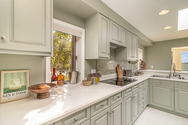 kitchen featuring decorative backsplash, sink, a wealth of natural light, and black electric stovetop