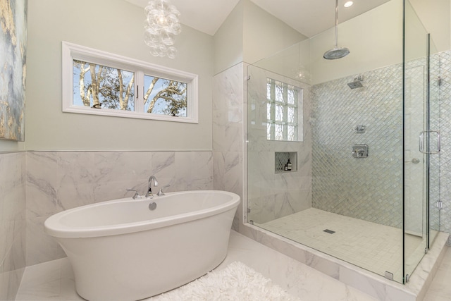 bathroom featuring tile walls and separate shower and tub