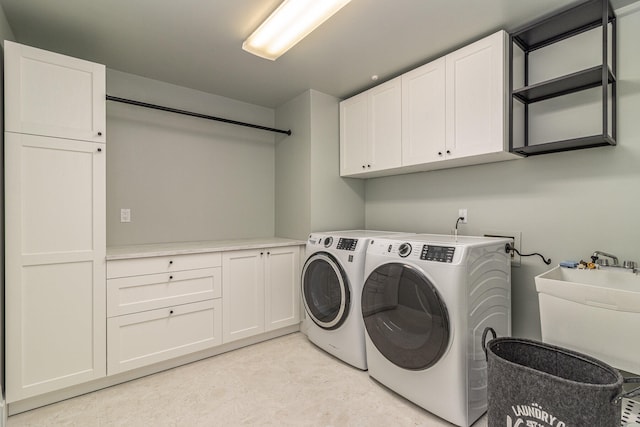 laundry area with cabinets, washer and clothes dryer, and sink