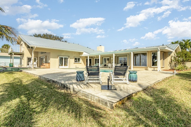 back of house featuring a lawn and a patio