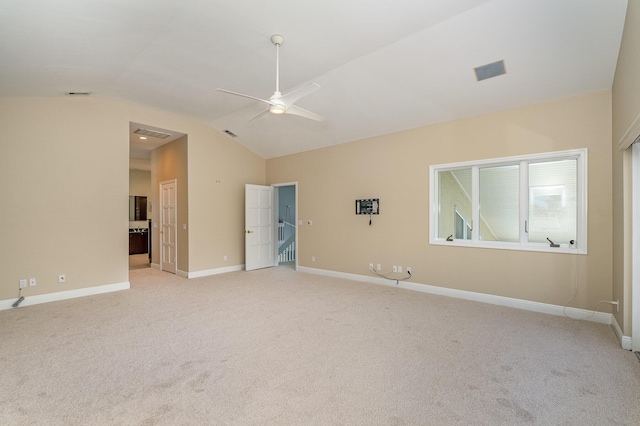 empty room with ceiling fan, light colored carpet, and vaulted ceiling