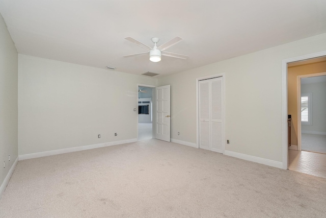 spare room featuring light carpet and ceiling fan