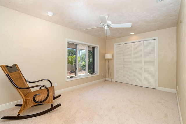 sitting room featuring light carpet and ceiling fan