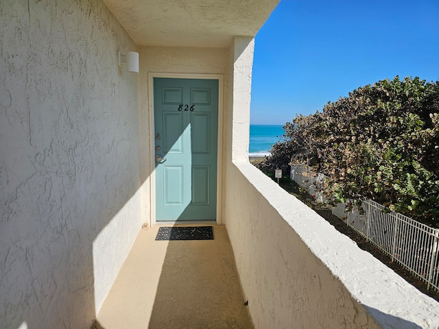 property entrance featuring a water view and a balcony