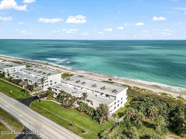 birds eye view of property with a water view and a beach view