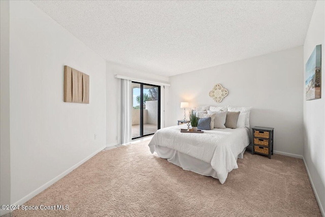 carpeted bedroom featuring access to outside and a textured ceiling