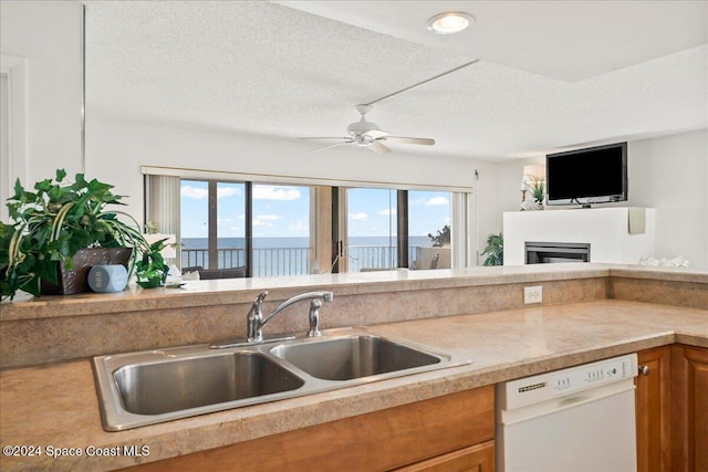 kitchen with ceiling fan, dishwasher, a textured ceiling, and sink