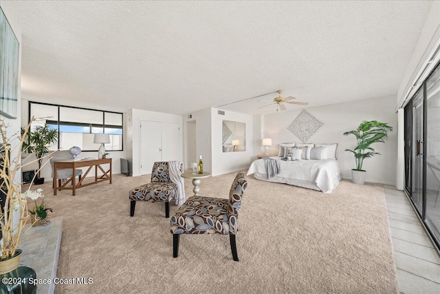 carpeted bedroom featuring ceiling fan, a closet, and a textured ceiling