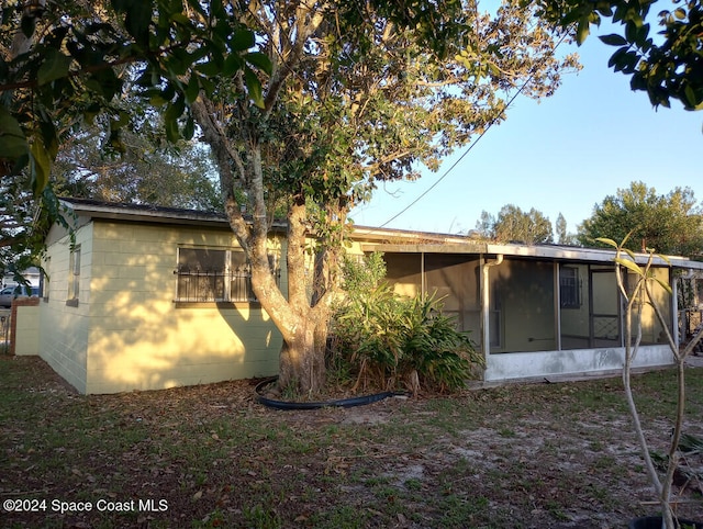 rear view of house featuring a sunroom