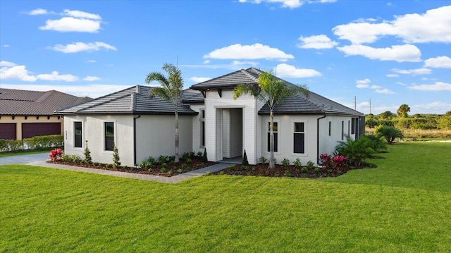 rear view of property with a garage and a lawn