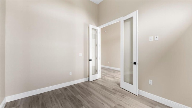 spare room with french doors and light wood-type flooring