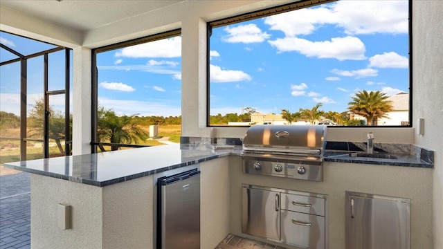 kitchen featuring a healthy amount of sunlight, refrigerator, and dark stone countertops