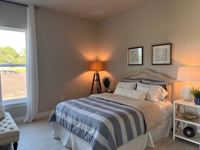 bedroom featuring multiple windows and light hardwood / wood-style floors