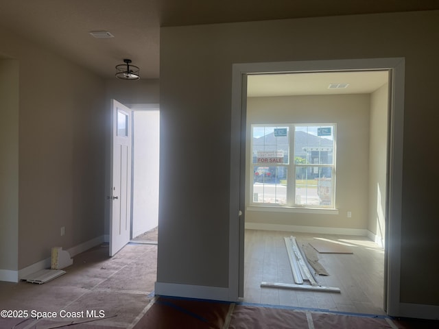 hall with baseboards and visible vents