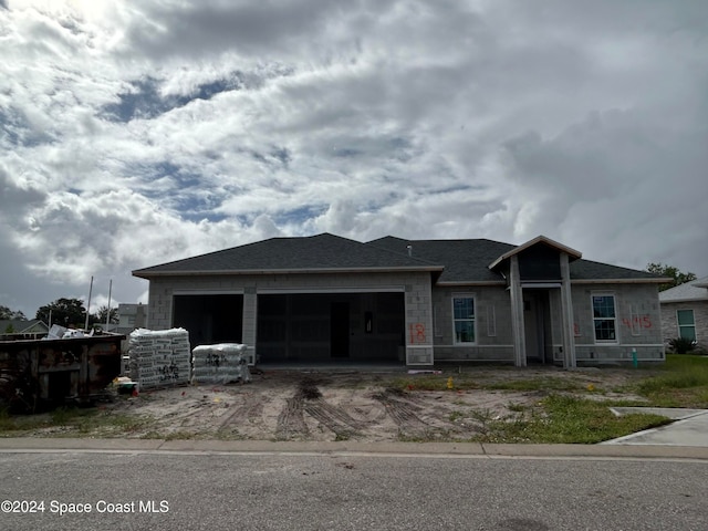 view of front of property featuring a garage, driveway, and roof with shingles