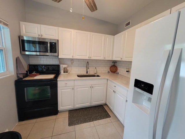 kitchen featuring white refrigerator with ice dispenser, ceiling fan, sink, white cabinets, and black electric range oven