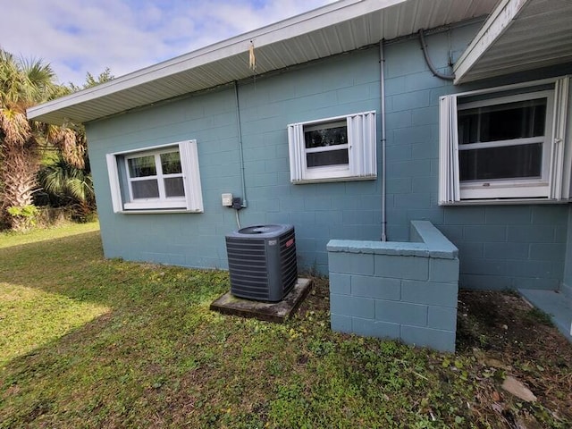 view of side of home featuring a yard and central AC unit