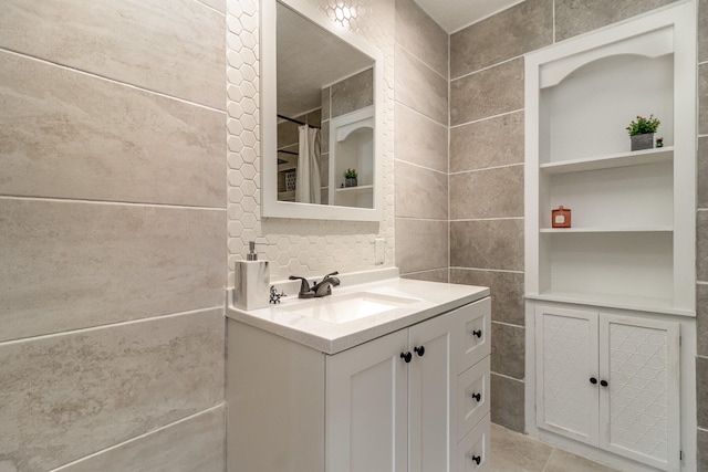 bathroom with tile floors, oversized vanity, and tile walls