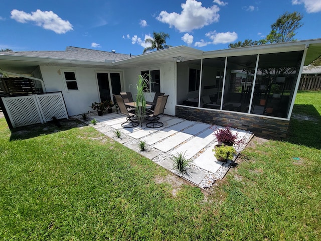 back of house with a patio area, a sunroom, and a lawn