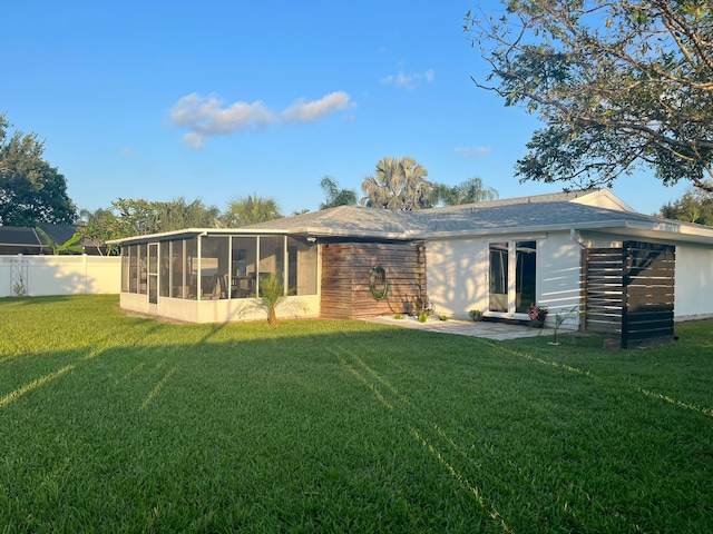 back of house with a yard and a sunroom