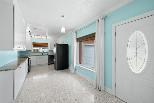 interior space featuring white cabinetry, track lighting, sink, stainless steel appliances, and pendant lighting