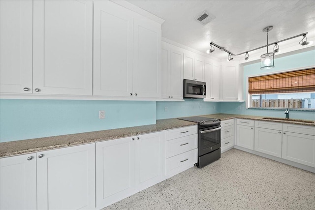 kitchen with sink, light stone counters, rail lighting, black electric range, and white cabinetry