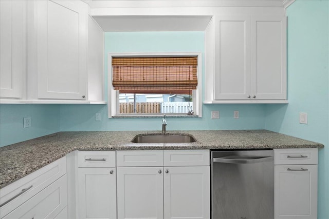 kitchen featuring stone counters, stainless steel dishwasher, white cabinetry, and sink