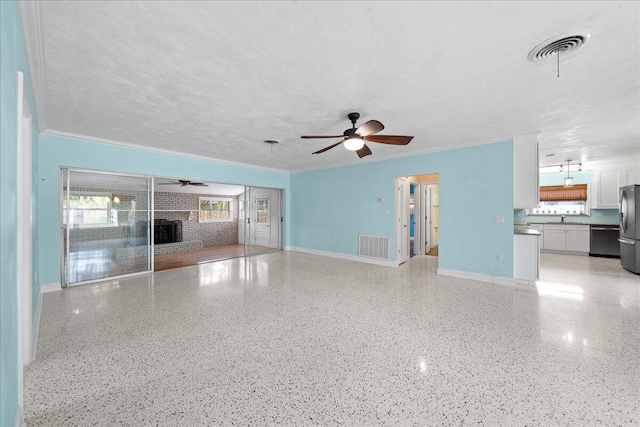 unfurnished living room featuring a textured ceiling, ceiling fan, and a brick fireplace